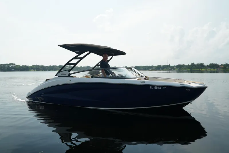 Slide: The Image of 2021 Yamaha Boats 252SE cruising on a calm lake under a clear sky. - 4