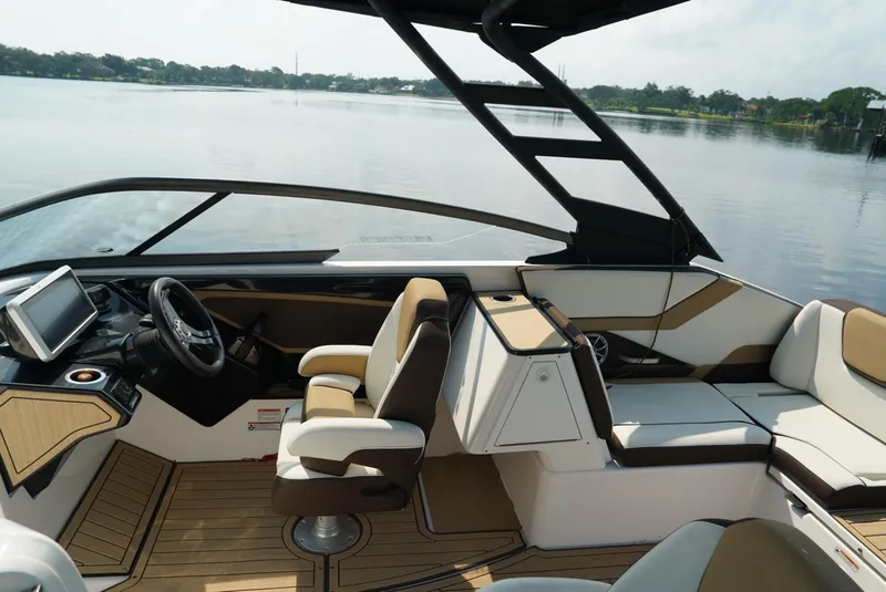 Slide: The Image of 2021 Yamaha Boats 252SE interior with sleek design and comfortable seating on a calm lake. - 8