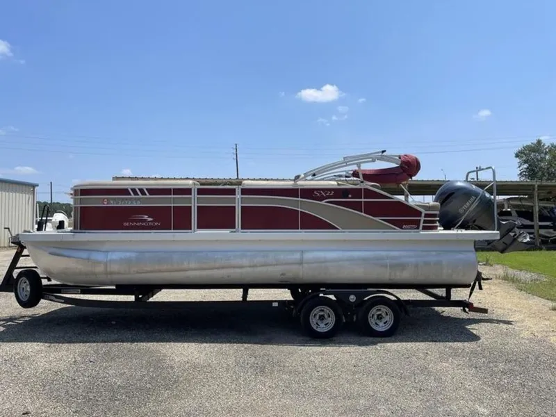 Slide: The Image of 2021 Bennington 22 SSBX pontoon boat on trailer, red and silver design. - 5
