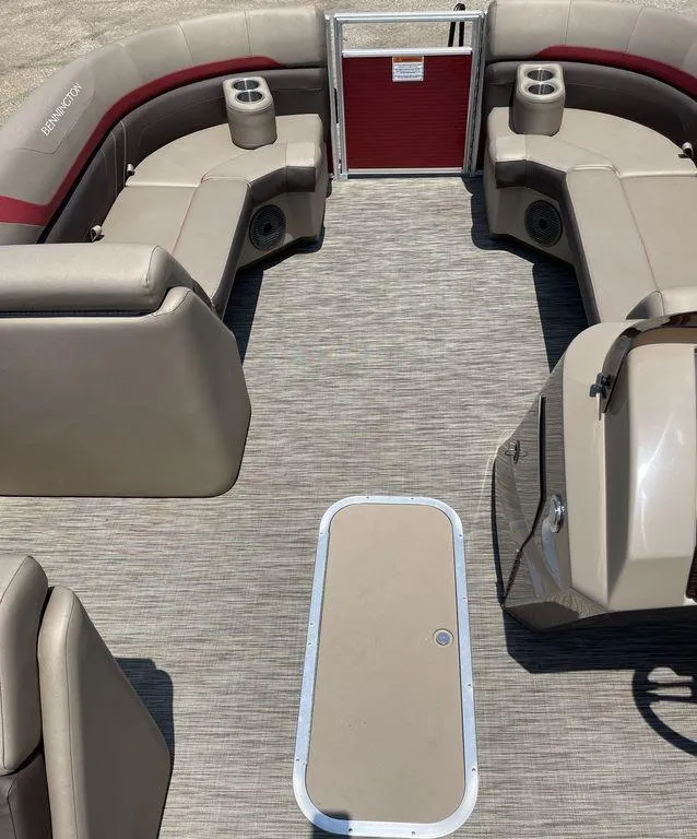 Slide: The Image of 2021 Bennington 22 SSBX pontoon boat interior with beige seating and red accents. - 8