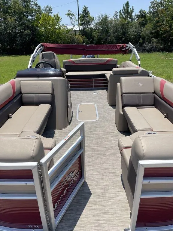 Slide: The Image of 2021 Bennington 22 SSBX pontoon boat with spacious seating and red accents. - 9