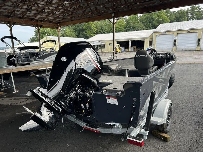 Slide: The Image of 2025 Lund ADVENTURE 1675 SS boat with Mercury outboard motor in a covered storage area. - 4