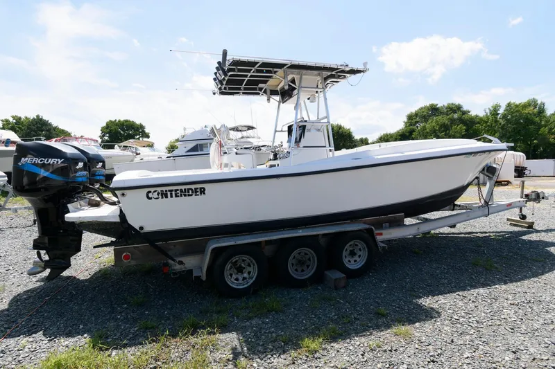 Slide: The Image of 1994 Contender 25 Tournament boat on trailer, featuring Mercury outboard engine. - 2