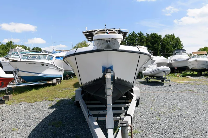 Slide: The Image of 1994 Contender 25 Tournament boat on trailer in a boatyard under clear blue sky. - 3