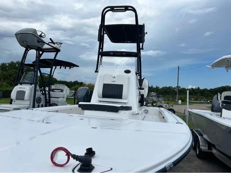 Slide: The Image of 2025 Tidewater 25 TPC Raptor boat with elevated helm, parked outdoors under cloudy sky. - 13