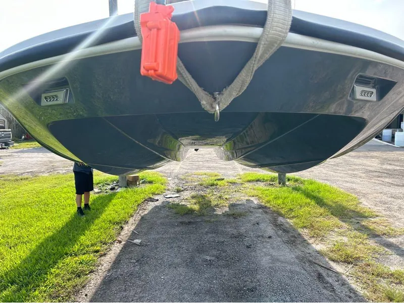 Slide: The Image of 2025 Tidewater 25 TPC Raptor boat hull, suspended outdoors, showcasing sleek design. - 24