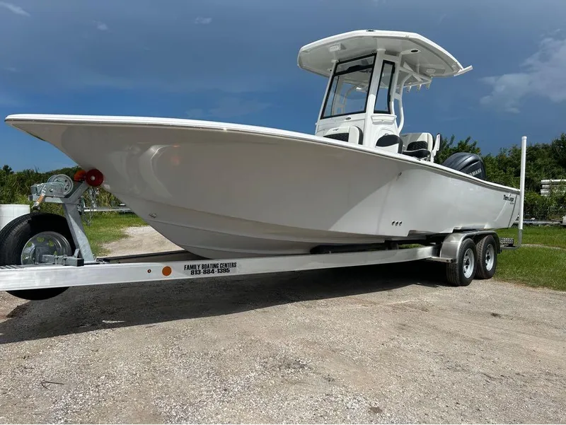 Slide: The Image of 2025 Tidewater 2500 Carolina Bay boat on trailer under clear sky. - 1