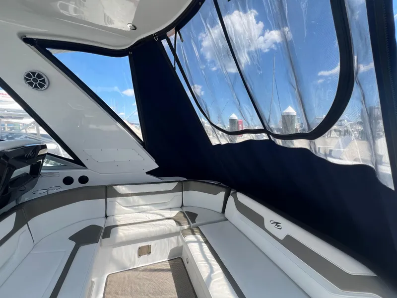 Slide: The Image of Interior of 2017 Monterey 355 Sport Yacht with white seating and clear canopy. - 13