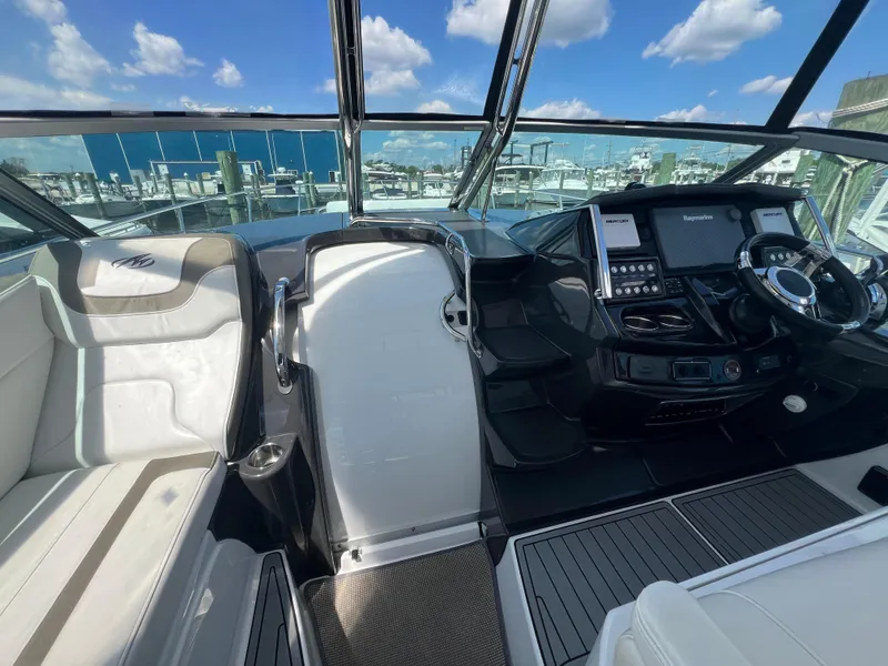 Slide: The Image of 2017 Monterey 355 Sport Yacht cockpit with modern controls and seating, under a clear blue sky. - 19