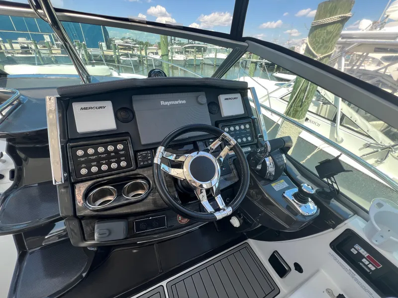Slide: The Image of 2017 Monterey 355 Sport Yacht helm with Raymarine and Mercury controls at marina. - 21