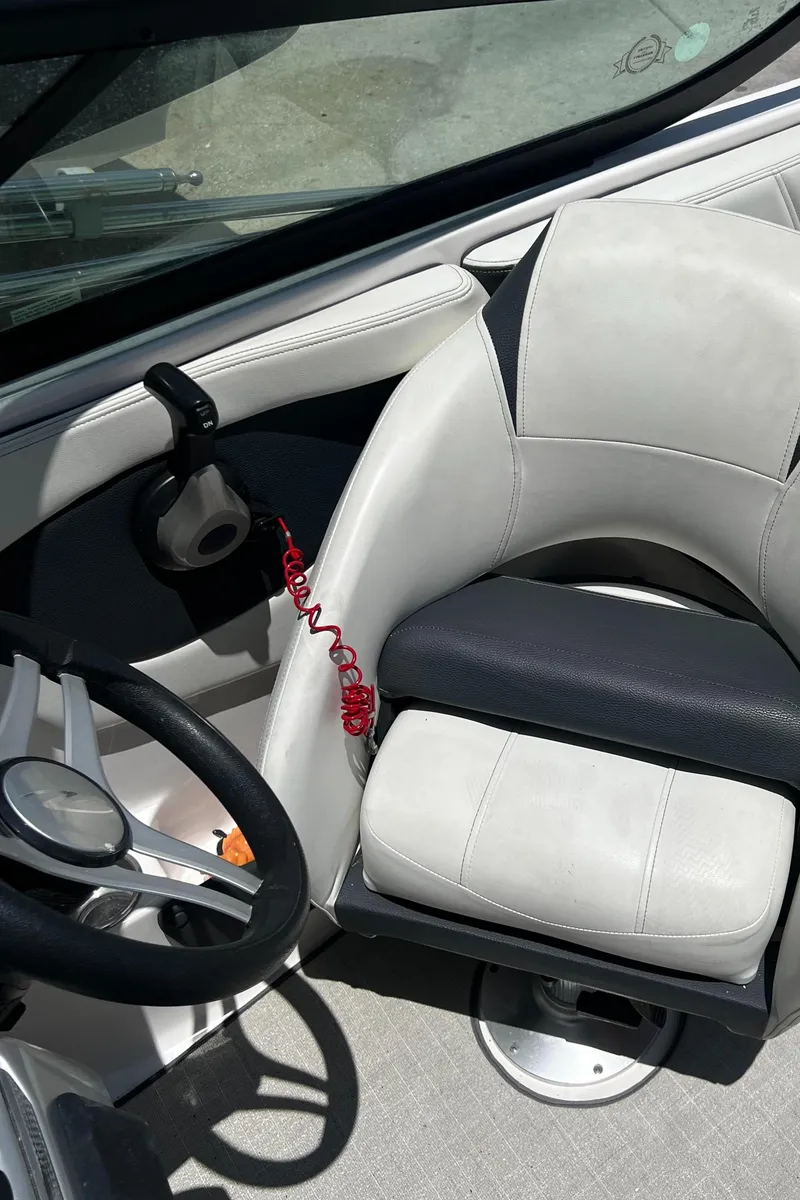 Slide: The Image of 2021 Regal 21 OBX boat interior with steering wheel and cushioned seat. - 10