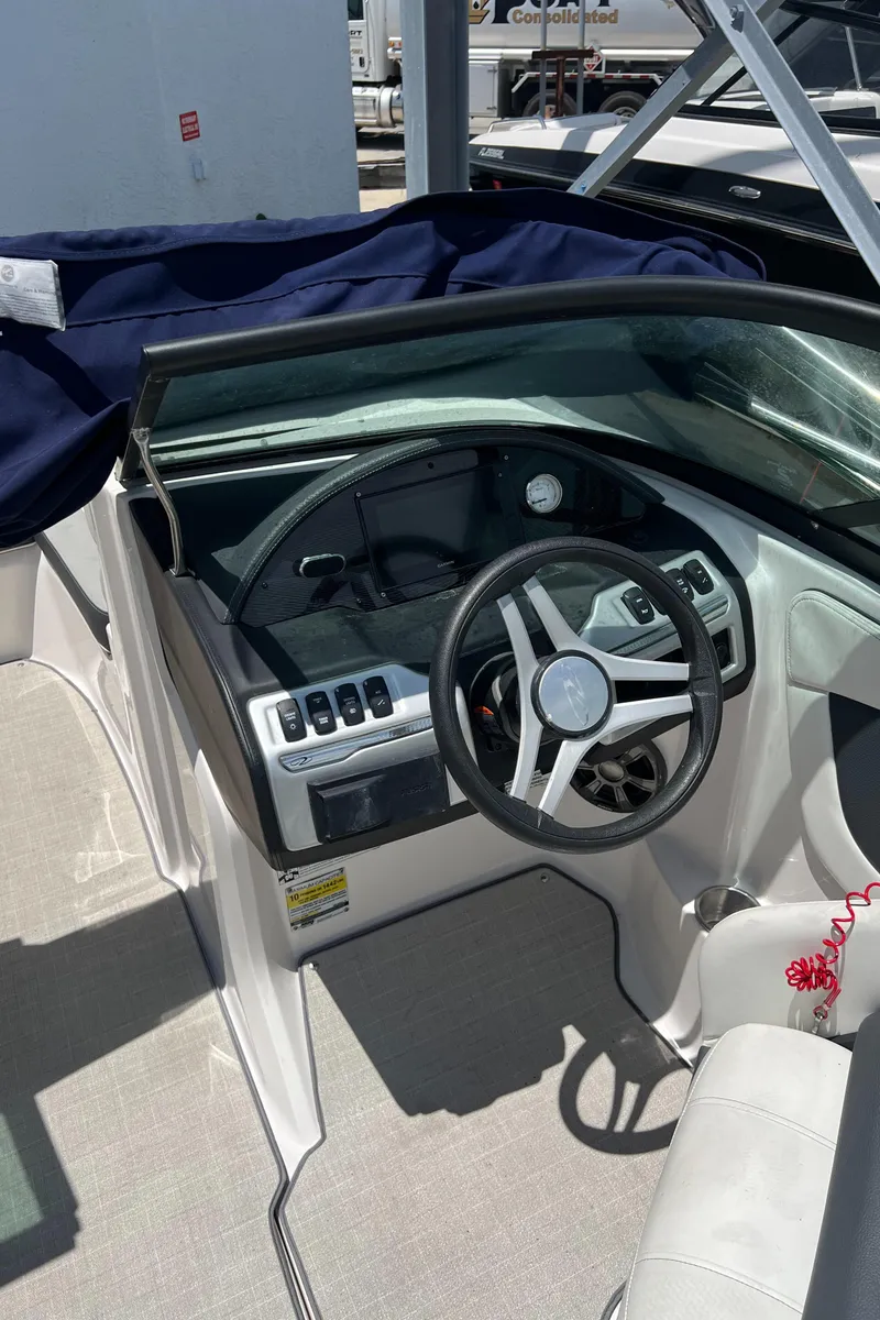 Slide: The Image of 2021 Regal 21 OBX boat cockpit with steering wheel and control panel. - 12