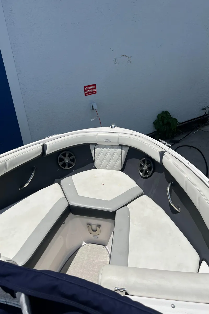 Slide: The Image of 2021 Regal 21 OBX boat interior with white seating and speakers. - 13