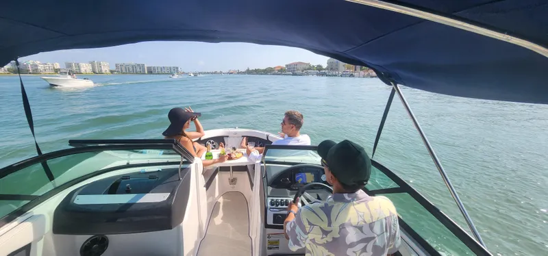 Slide: The Image of People enjoying a ride on a 2021 Regal 21 OBX boat in sunny waters. - 18