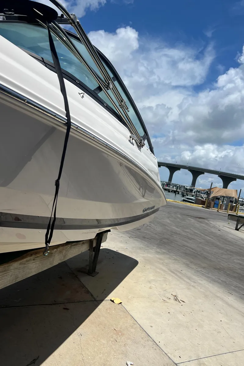 Slide: The Image of 2021 Regal 21 OBX boat on trailer, blue sky, bridge in background. - 3