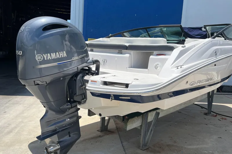 Slide: The Image of 2021 Regal 21 OBX boat with Yamaha outboard motor, docked outdoors. - 5
