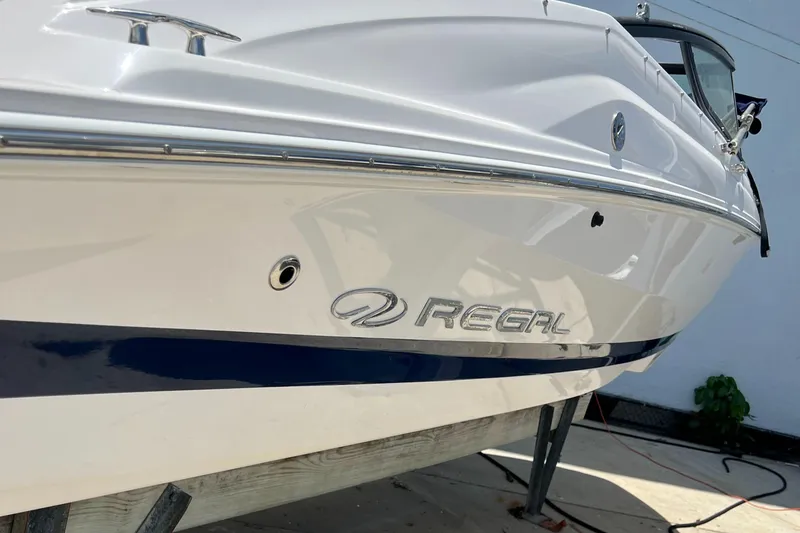 Slide: The Image of 2021 Regal 21 OBX boat side view with logo, white and blue design. - 6