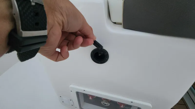 Slide: The Image of Hand operating a control on a 2024 Tidewater 2700 Carolina Bay boat. - 12