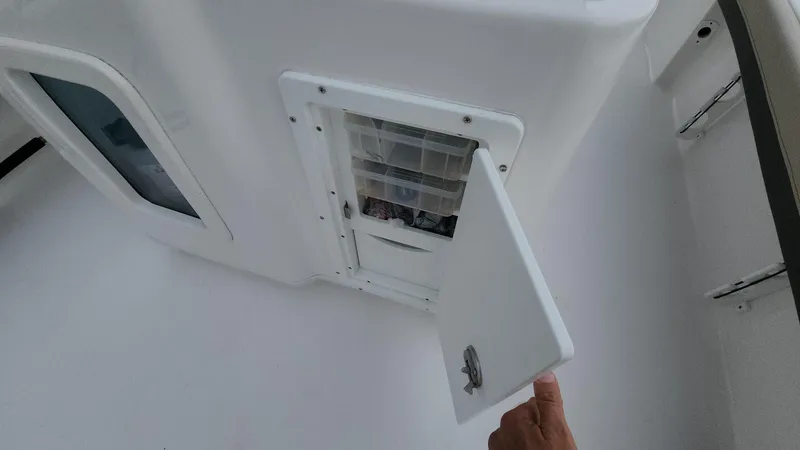 Slide: The Image of 2024 Tidewater 2700 Carolina Bay storage compartment with open door, showcasing interior space. - 14