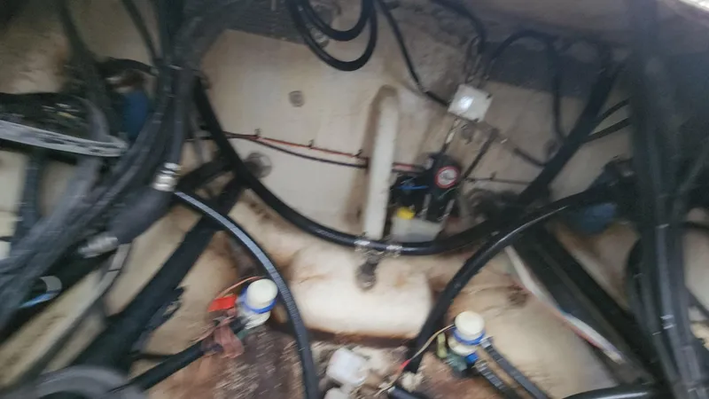 Slide: The Image of 2024 Tidewater 2700 Carolina Bay engine compartment with hoses and mechanical components. - 16