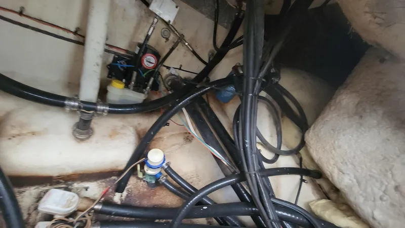 Slide: The Image of 2024 Tidewater 2700 Carolina Bay boat interior showing wiring and plumbing components. - 17