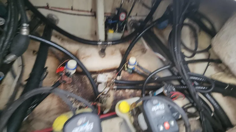 Slide: The Image of Engine compartment of a 2024 Tidewater 2700 Carolina Bay boat with visible wiring and components. - 18