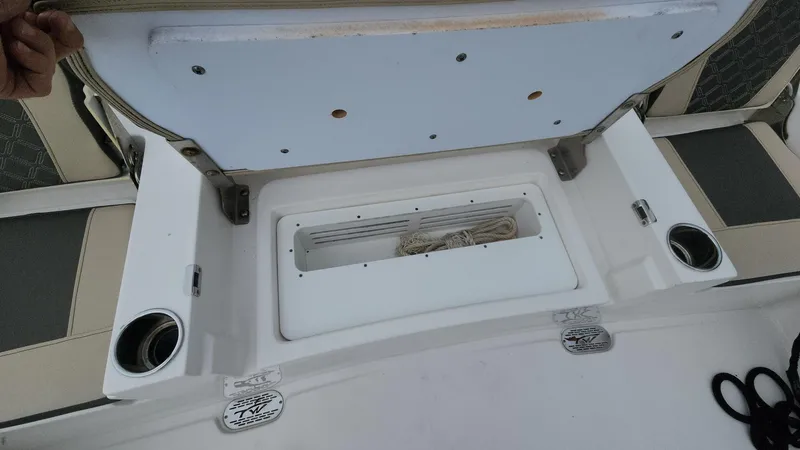 Slide: The Image of 2024 Tidewater 2700 Carolina Bay boat storage compartment with cup holders and rope. - 20