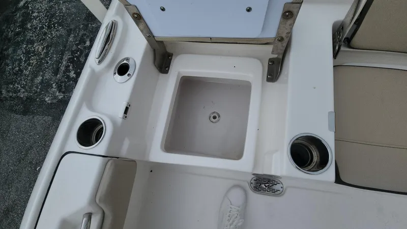 Slide: The Image of 2024 Tidewater 2700 Carolina Bay boat interior with cup holders and storage compartment. - 21