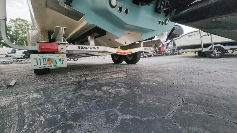 Slide: The Image of 2024 Tidewater 2700 Carolina Bay boat on Road King trailer, Florida license plate visible. - 25