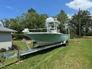 Slide: The Image of 2024 Tidewater 2700 Carolina Bay boat on trailer in grassy yard. - 3