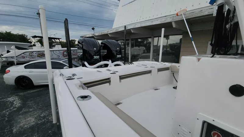 Slide: The Image of 2024 Tidewater 2700 Carolina Bay boat with dual Yamaha 300 engines, parked near a white car. - 33