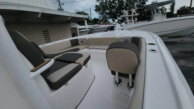 Slide: The Image of 2024 Tidewater 2700 Carolina Bay boat interior with seating and console, docked outdoors. - 38