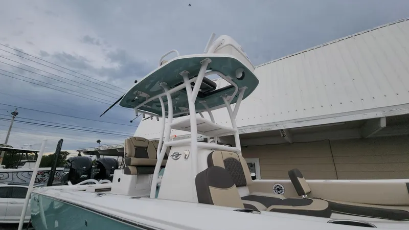 Slide: The Image of 2024 Tidewater 2700 Carolina Bay boat with T-top and seating, under cloudy sky. - 40