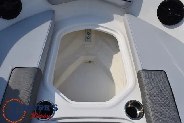 Slide: The Image of 2025 Bayliner VR5 Bowrider Outboard, open storage compartment, gray seating, cup holders, marine speakers. - 13