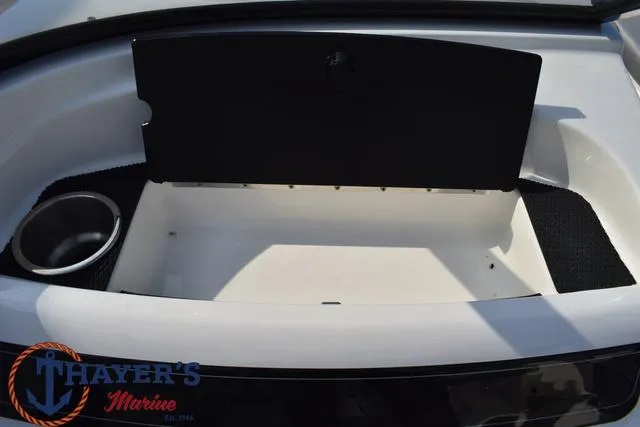 Slide: The Image of 2025 Bayliner VR5 Bowrider storage compartment with cup holder, Thayer's Marine logo. - 25
