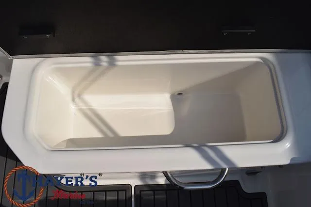 Slide: The Image of 2025 Bayliner VR5 Bowrider storage compartment, white interior, open lid, boat accessory. - 36