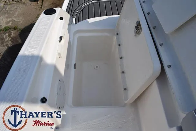 Slide: The Image of 2025 Bayliner VR5 Bowrider storage compartment, open lid, Thayer's Marine logo visible. - 40
