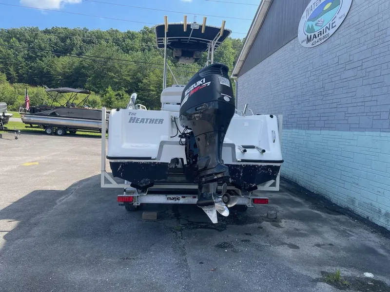 Slide: The Image of 2007 ProKat CS200 boat with Suzuki outboard motor, parked near a marine shop. - 4