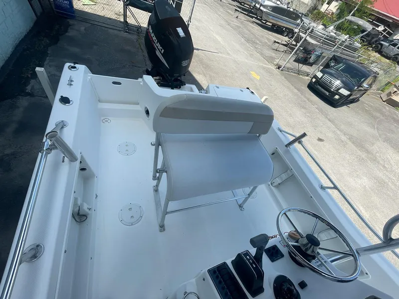 Slide: The Image of 2007 ProKat CS200 boat interior with steering wheel and seating, docked outdoors. - 5