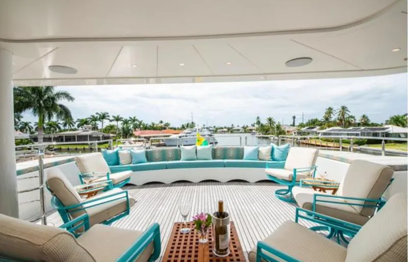 Slide: The Image of Luxurious Horizon 136 Premier yacht deck with elegant seating, wine, and scenic waterfront view. - 10