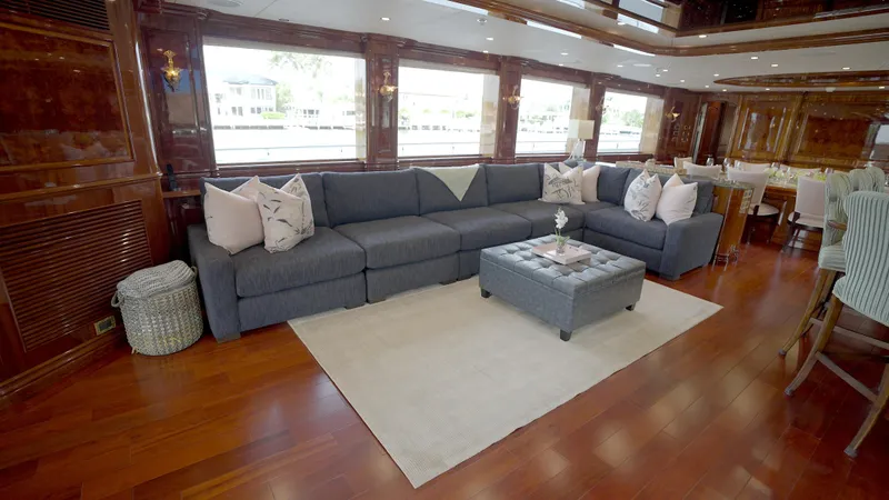 Slide: The Image of Luxurious yacht interior with a spacious gray sofa, elegant decor, and wooden flooring. Horizon 136 Premier 2010. - 22