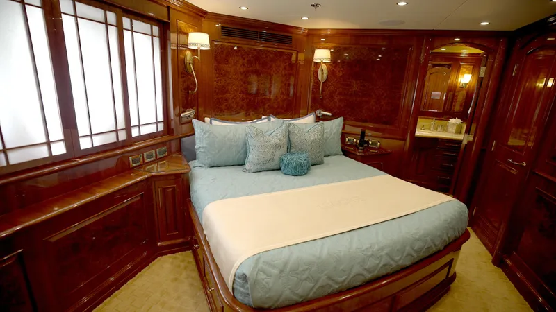 Slide: The Image of Luxurious bedroom interior on 2010 Horizon 136 Premier yacht, featuring elegant wood paneling and plush bedding. - 41