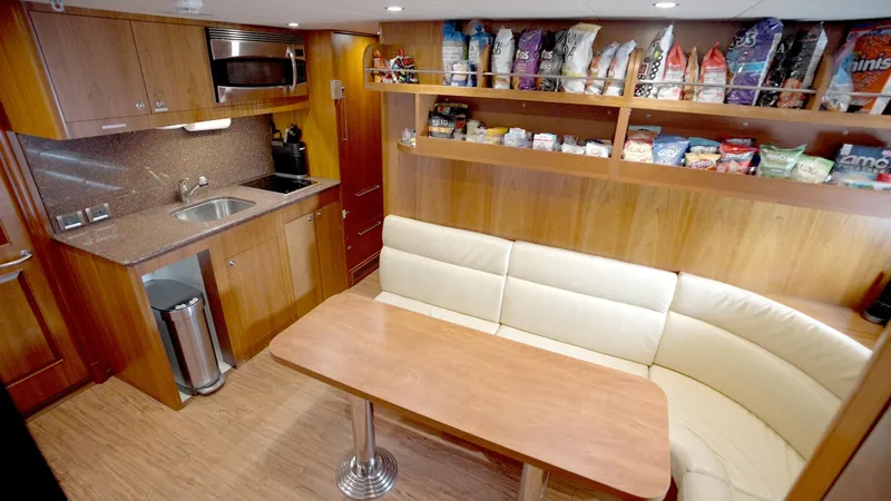 Slide: The Image of Luxurious yacht kitchen with wood cabinetry, dining area, and snack shelves on Horizon 136 Premier. - 45