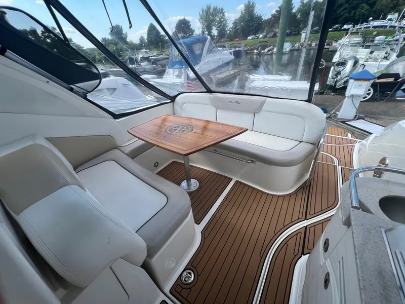 Slide: The Image of 2010 Sea Ray 350 Sundancer interior with white seating and wooden table. - 14