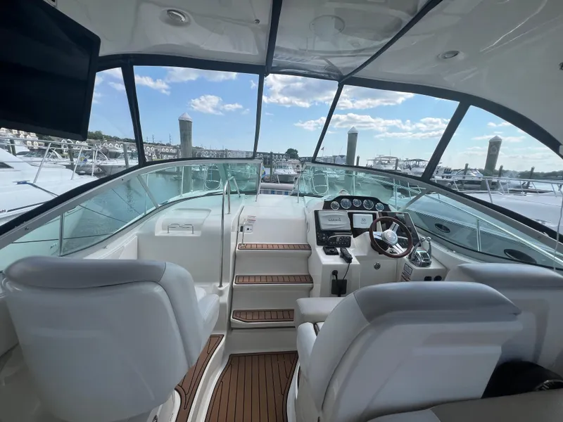 Slide: The Image of 2010 Sea Ray 350 Sundancer cockpit with modern controls and panoramic marina view. - 15