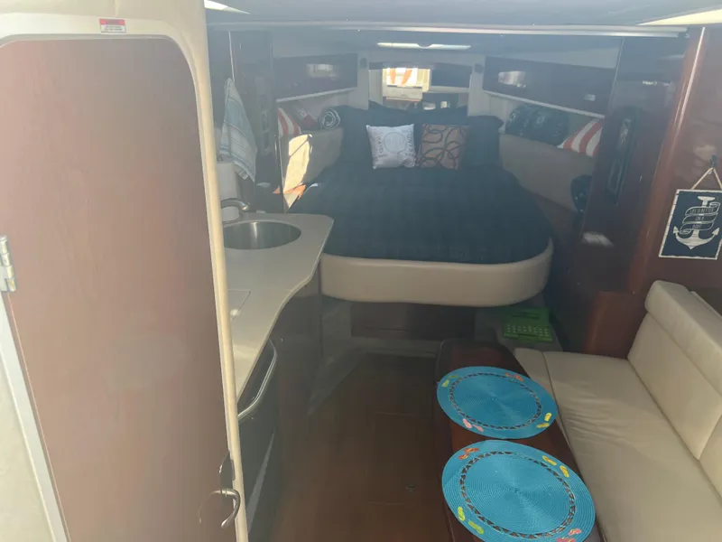 Slide: The Image of Interior of 2010 Sea Ray 350 Sundancer with bed, kitchenette, and seating area. - 23