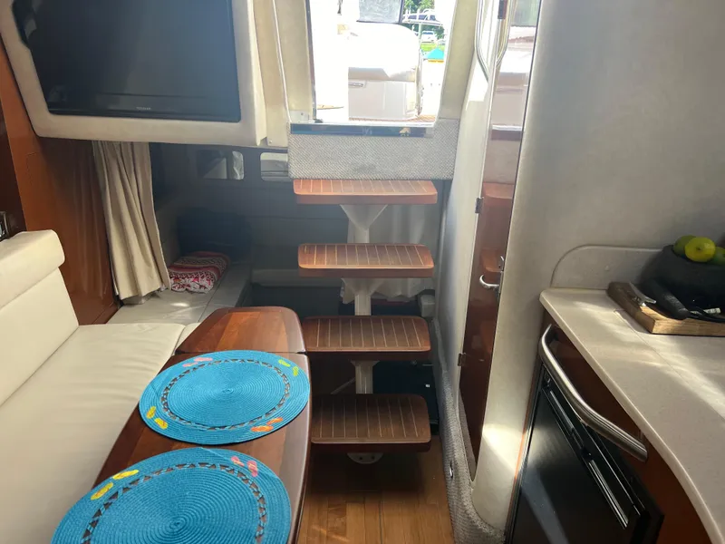 Slide: The Image of Interior of 2010 Sea Ray 350 Sundancer yacht with wooden steps and dining area. - 25