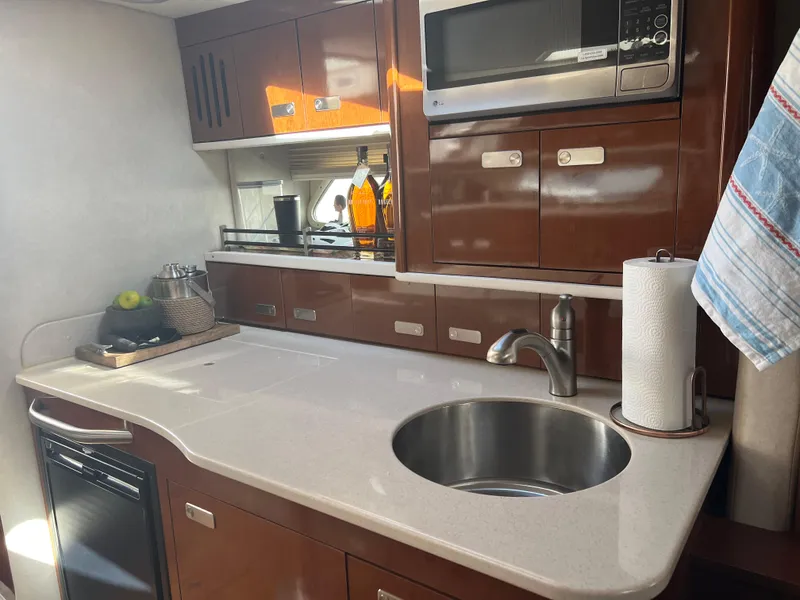 Slide: The Image of 2010 Sea Ray 350 Sundancer yacht kitchen with sink, microwave, and storage cabinets. - 26
