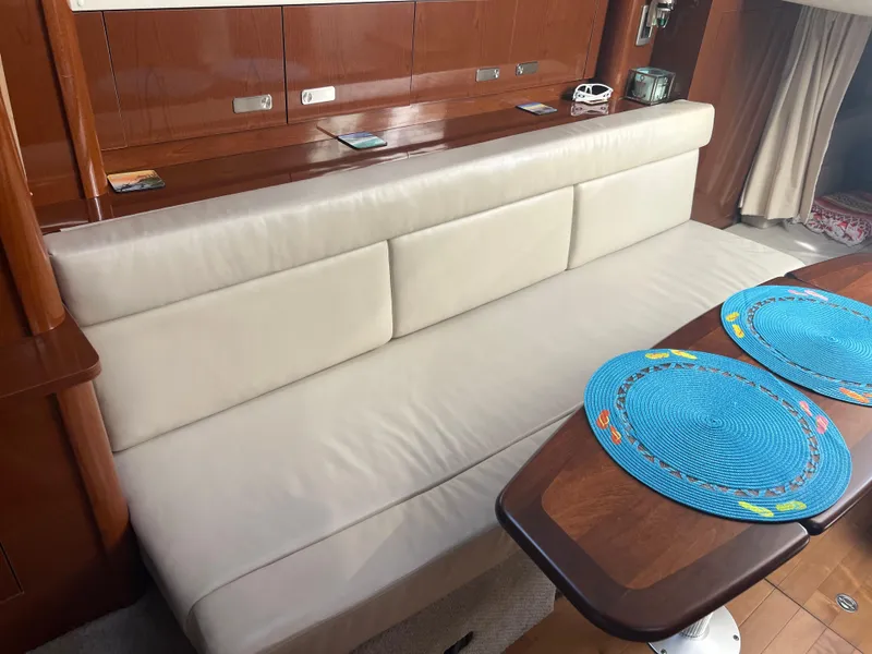 Slide: The Image of Interior of 2010 Sea Ray 350 Sundancer with cream sofa and wooden table. - 28