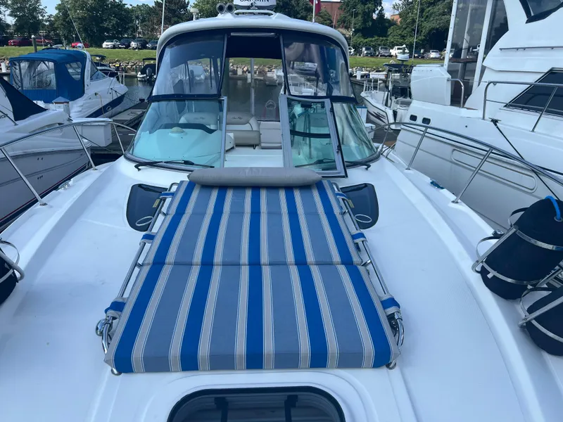 Slide: The Image of 2010 Sea Ray 350 Sundancer yacht with striped sunbed on deck, docked at marina. - 9